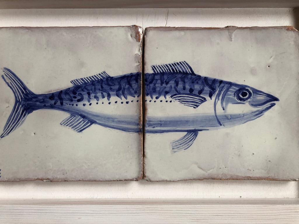 Two ceramic tiles with blue fish illustrations on a white background. Azulejo portuguese. Kézműves fali csempe.
