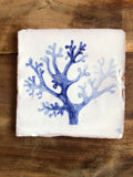 Square tile with blue coral design on a wooden surface. Azulejo portuguese. Kézműves fali csempe.